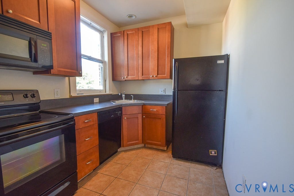 120 S Arthur Ashe Boulevard, #1, Richmond, VA 23220 Kitchen featuring wood cabinetry, dark countertops, black appliances, a window above the sink, and tile flooring