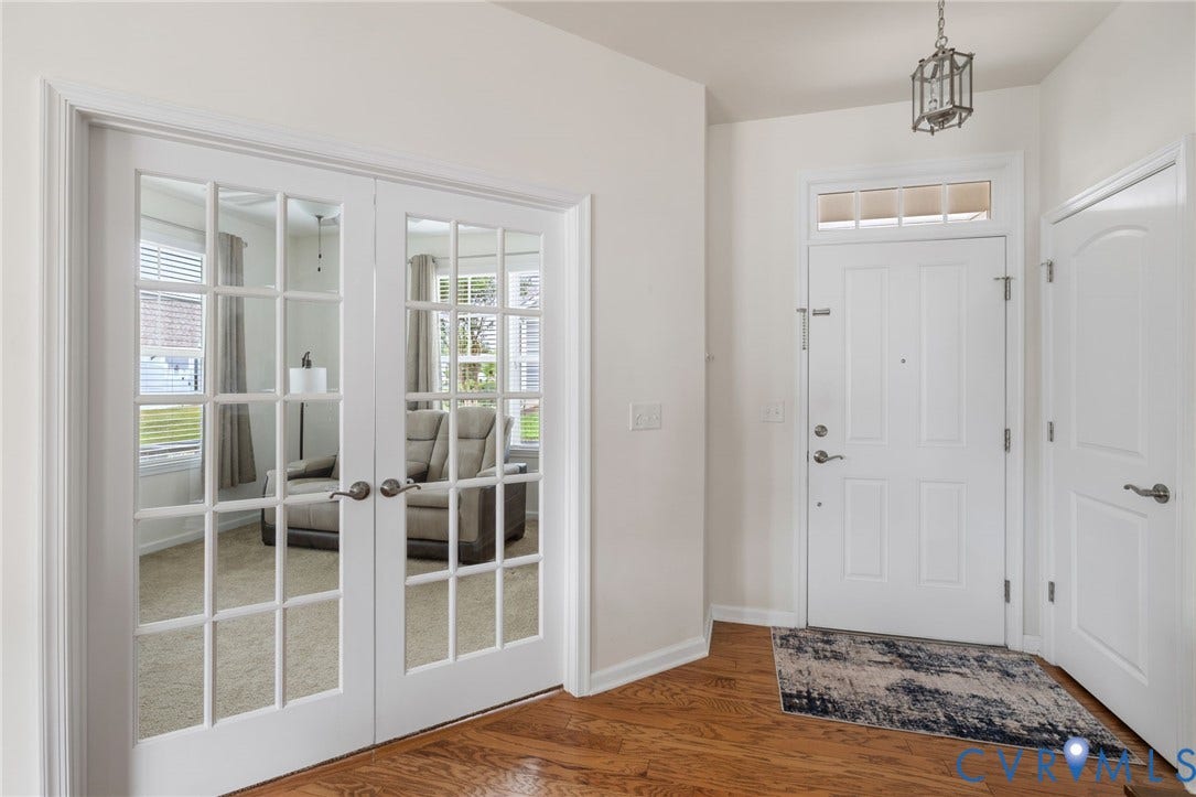 12128 Magnolia Bluff Court, Villas At Magnolia Lakes, Chester, VA 23831 Entryway featuring wood-finish flooring, a white paneled entry door with transom window, and a lantern-style ceiling fixture