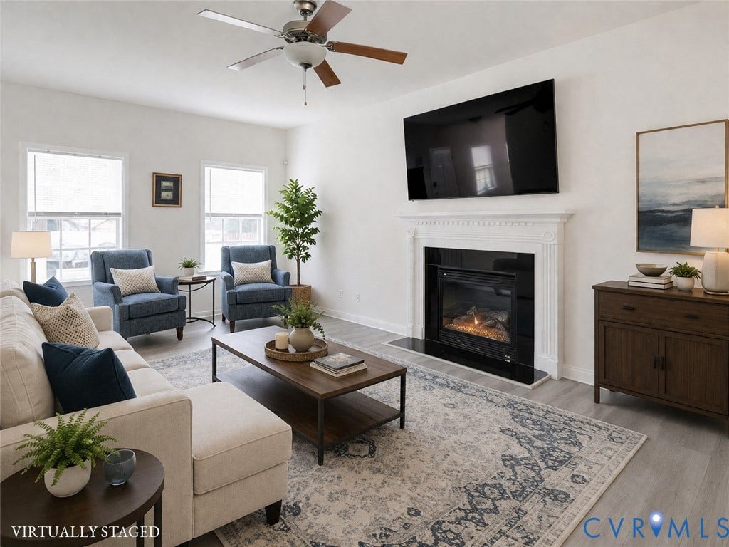 2244 Thomas Kenney Drive, Henrico, VA 23060 Living room featuring a decorative fireplace with a white mantel and black surround, recessed television, and wood-finish flooring- Virtually Staged