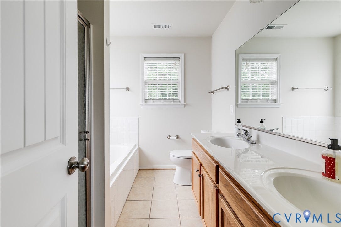 2244 Thomas Kenney Drive, Henrico, VA 23060 Primary En-Suite Bathroom Featuring Tile Flooring, Double Vanity Sinks, Walk-In Shower, and Garden Tub.