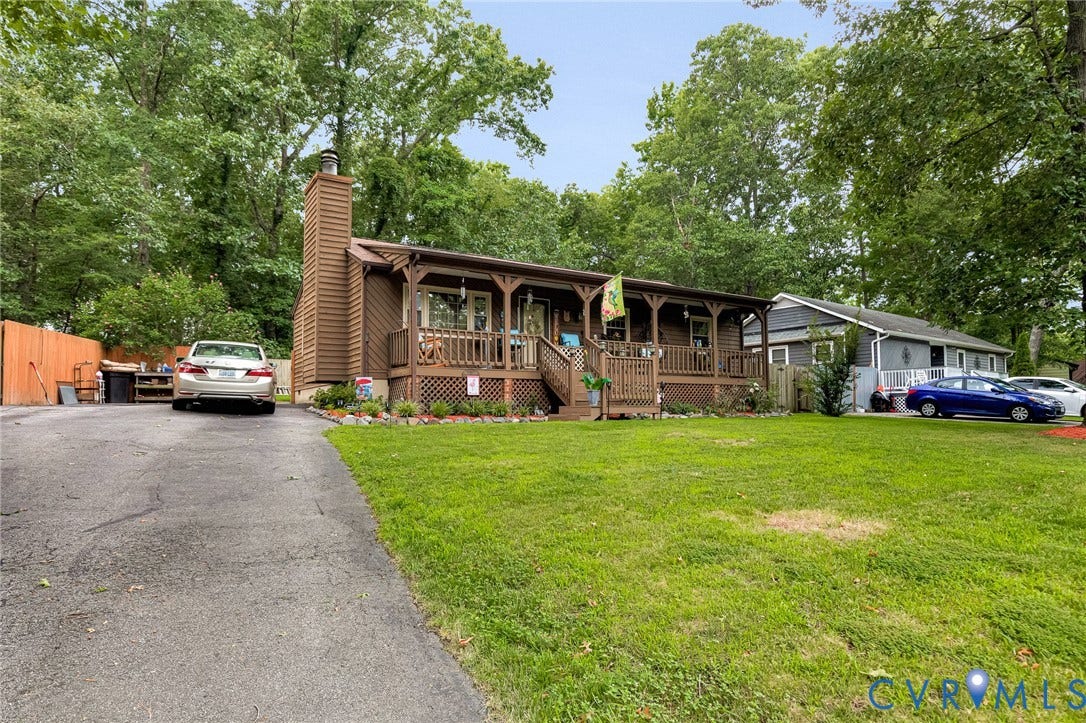 11330 Great Branch Drive, Chester, VA 23831 Brown siding exterior with a full-length covered porch featuring decorative railings and columns