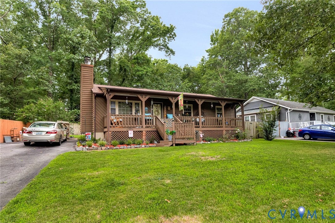 11330 Great Branch Drive, Chester, VA 23831 Single-story brown-sided residence with a covered front porch featuring a railing and lattice detailing