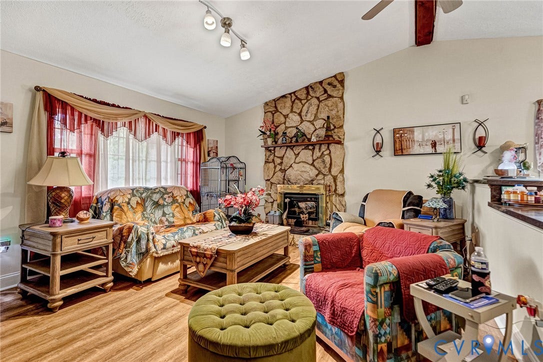 11330 Great Branch Drive, Chester, VA 23831 Living space featuring a stone-clad fireplace with a hearth, wood-finish flooring, and a ceiling fan