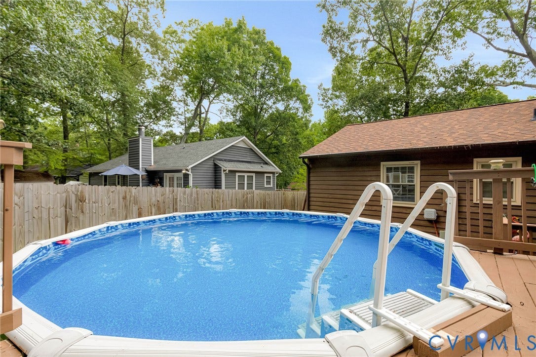 11330 Great Branch Drive, Chester, VA 23831 Above-ground pool with integrated entry steps and a surrounding wood-finish deck
