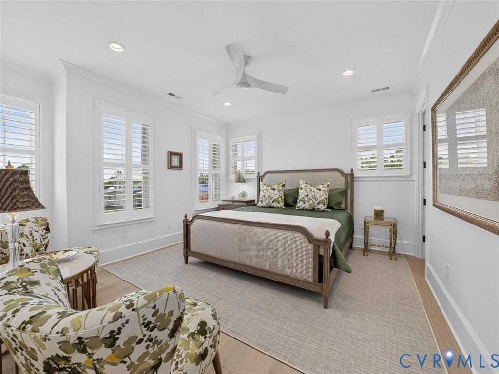 Spacious room featuring multiple windows with plantation shutters, recessed lighting, crown molding, and wood-finish flooring