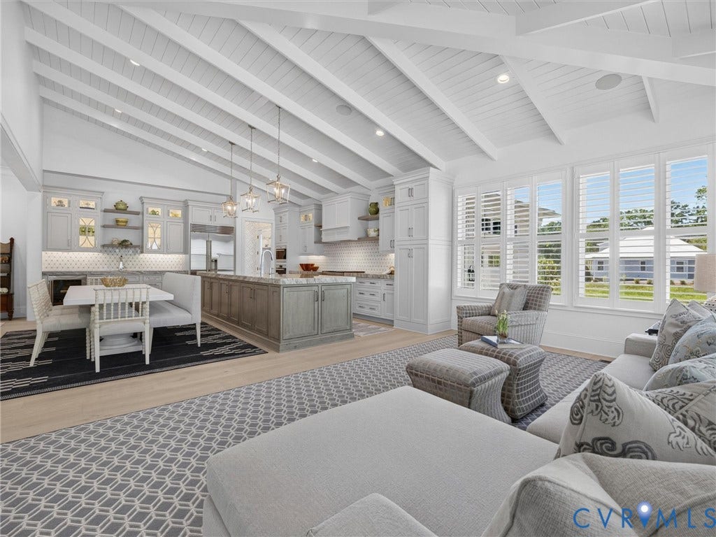 Vaulted wood-planked ceilings with exposed beams, light wood-finish flooring, and a kitchen featuring a large island with stone countertop, white shaker cabinetry, and a subway tile backsplash
