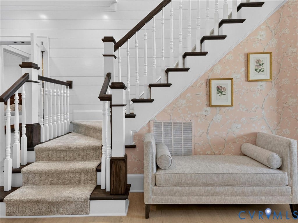 Carpeted staircase with dark wood treads and white balusters