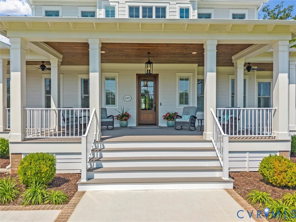 Expansive front porch featuring a wood-paneled ceiling, multiple ceiling fans, and a classic lantern pendant light