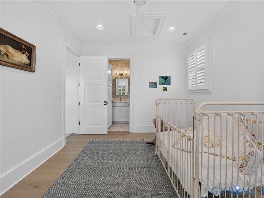 Light-colored wood-finish flooring complements crisp white walls and crown molding