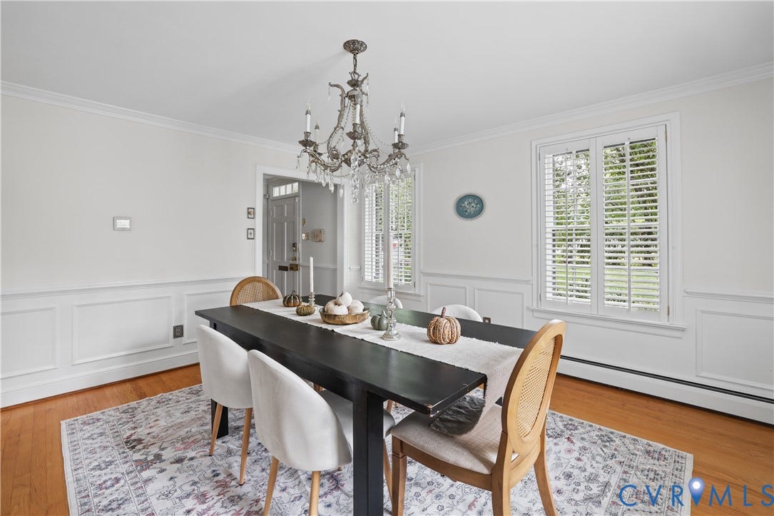 5418 Cary Street Road, Richmond, VA 23226 Dining area featuring wainscoting, wood-finish flooring, a tiered crystal chandelier, and shuttered windows