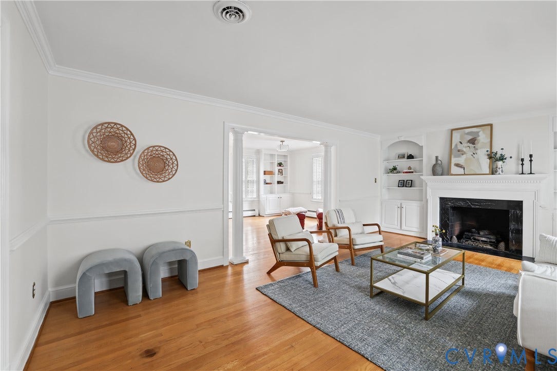 5418 Cary Street Road, Richmond, VA 23226 Living area featuring wood-finish flooring, a fireplace with a stone-surround and mantle, built-in shelving, decorative crown molding, and architectural columns