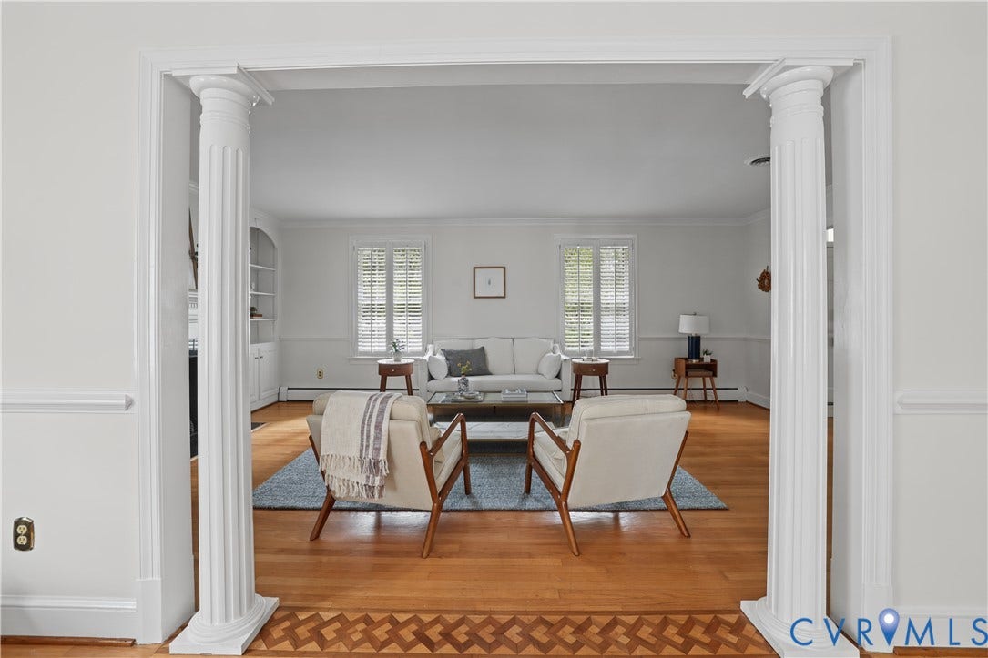 5418 Cary Street Road, Richmond, VA 23226 Architectural entryway featuring fluted columns, hardwood flooring with decorative inlay detail, and built-in shelving