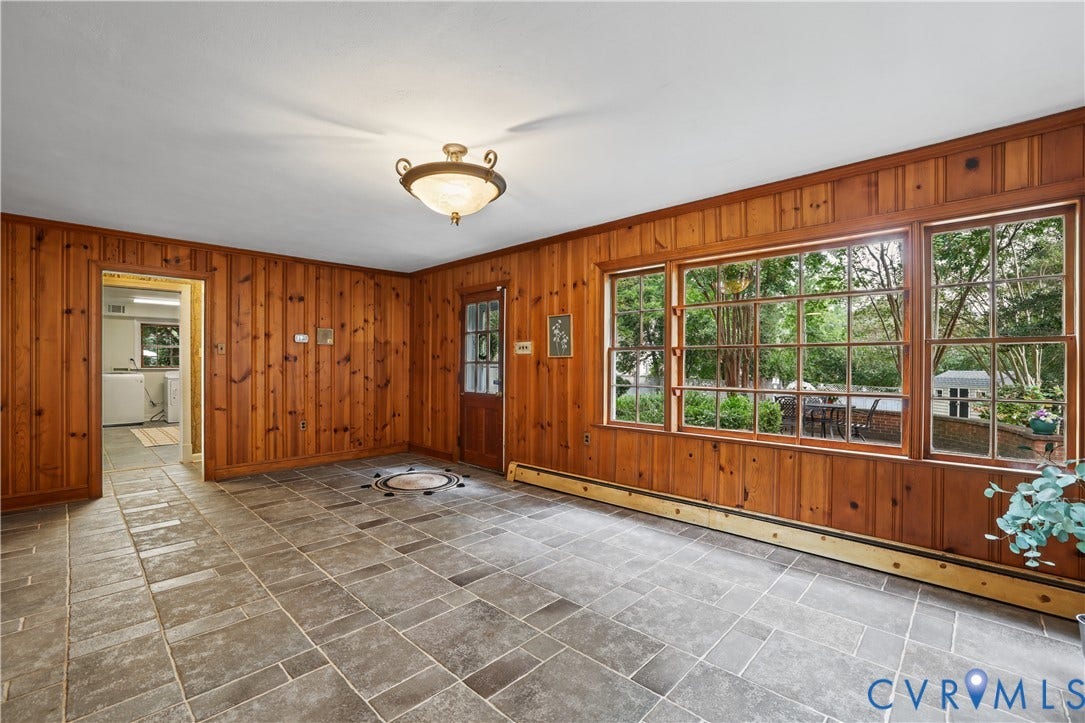 5418 Cary Street Road, Richmond, VA 23226 Wood-paneled interior walls, large multi-pane windows, natural stone flooring, a glass-panel wooden entry door, looking into Backyard.