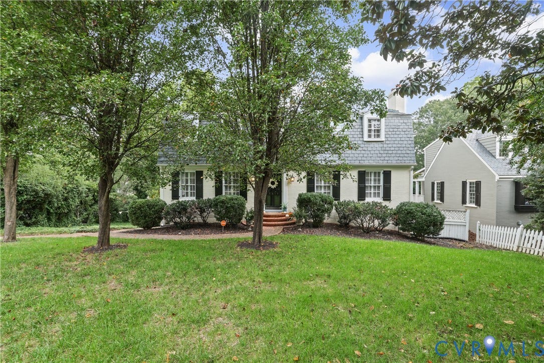5418 Cary Street Road, Richmond, VA 23226 Dutch Colonial exterior featuring a gambrel roof, multi-pane windows with dark shutters, a brick front stoop, and a white picket fence