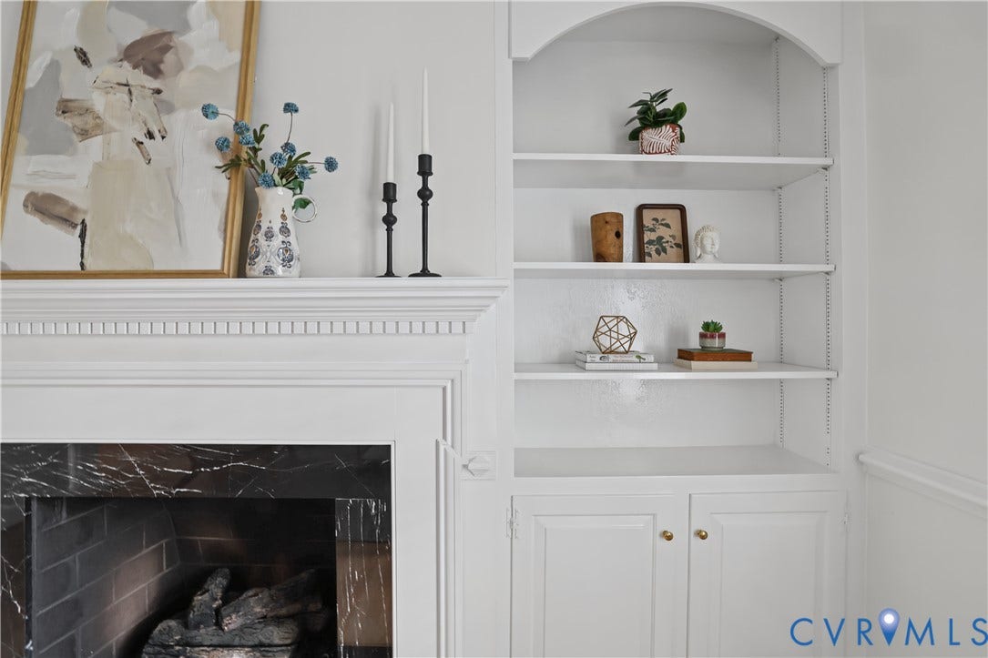5418 Cary Street Road, Richmond, VA 23226 Fireplace featuring a dark stone surround, crown molding, and built-in shelving with lower cabinetry