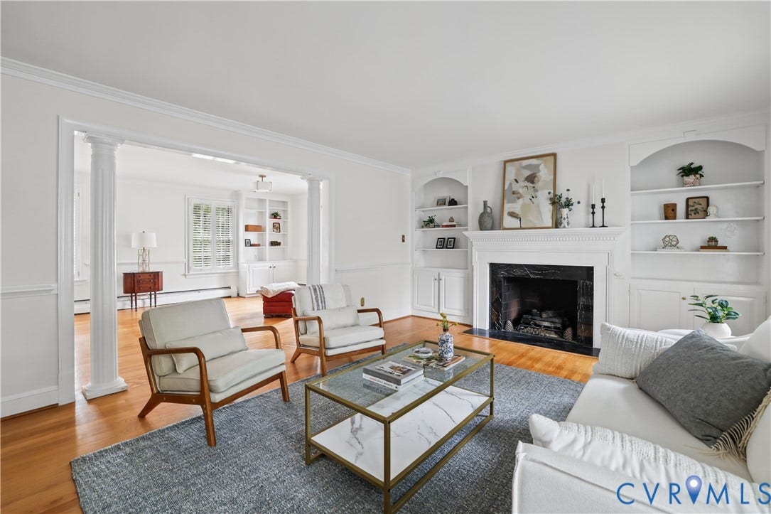 5418 Cary Street Road, Richmond, VA 23226 Fireplace with a stone surround, wood-finish flooring, custom built-in cabinetry, and decorative columns