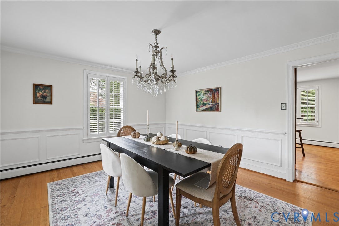 5418 Cary Street Road, Richmond, VA 23226 Dining area featuring wood-finish flooring, white wainscoting, multi-pane windows with plantation shutters, and a tiered crystal chandelier