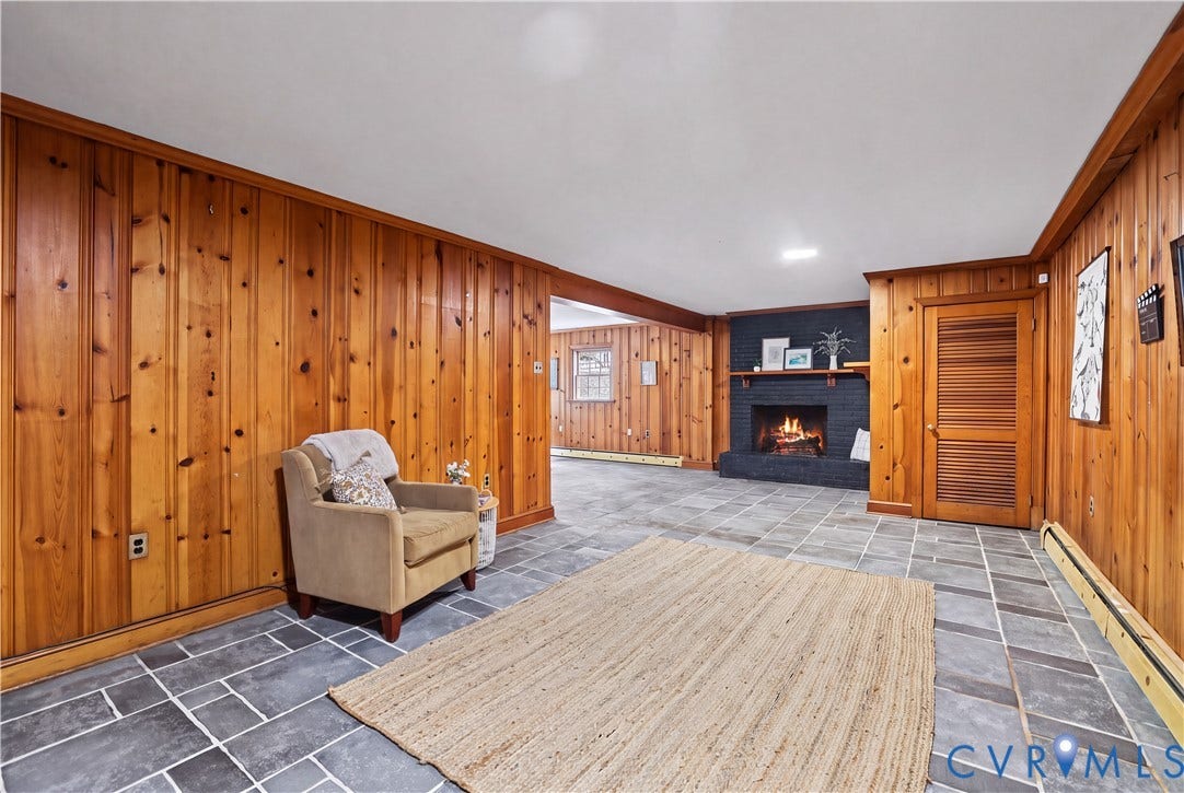 5418 Cary Street Road, Richmond, VA 23226 Basement Rec Rm featuring wood paneling, slate tile flooring, a painted brick fireplace with a mantel, and a louvered wooden door