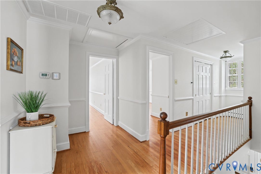 5418 Cary Street Road, Richmond, VA 23226 Interior hallway featuring wood-finish flooring, chair rail molding, solid-panel doors, and a wood-and-spindle stair railing