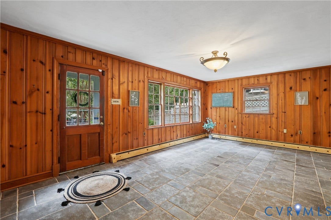 5418 Cary Street Road, Richmond, VA 23226 Wood-paneled wall treatment, stone flooring, multi-pane glass entrance door, and multi-pane window and door to patio