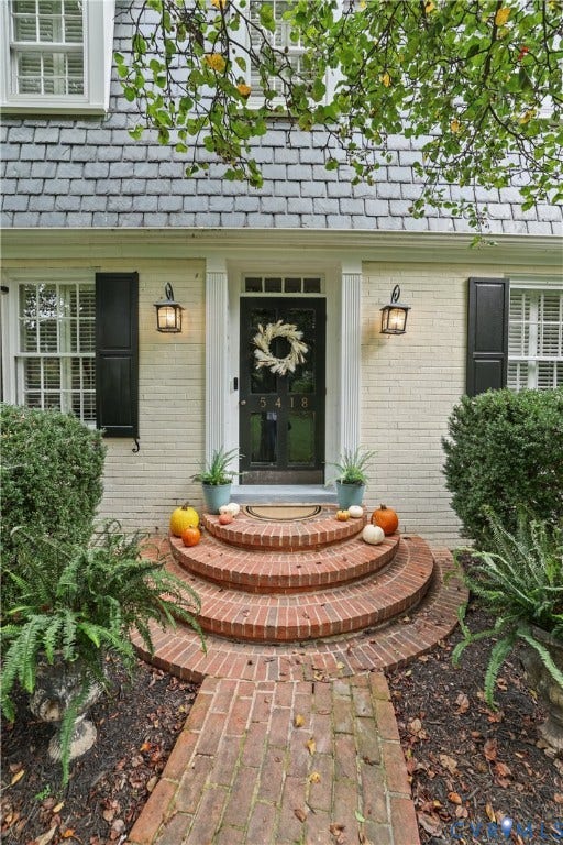 5418 Cary Street Road, Richmond, VA 23226 Exterior facade featuring painted brick, classic dark shutters, multi-pane windows, a dark glass-panel front door with transom light, and circular brick entry steps