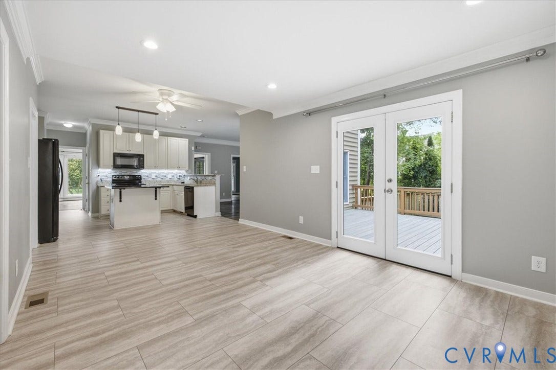 Spacious room with light-toned plank flooring, light grey walls, and white trim