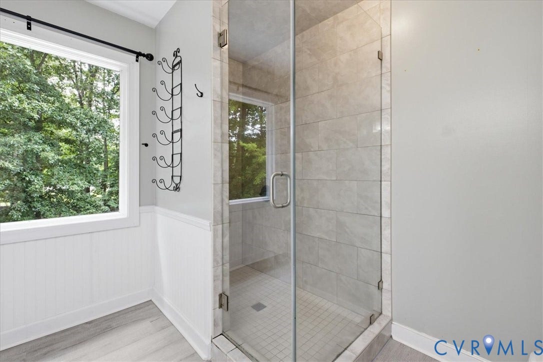 ... a glass-enclosed shower with tile surround and floor.