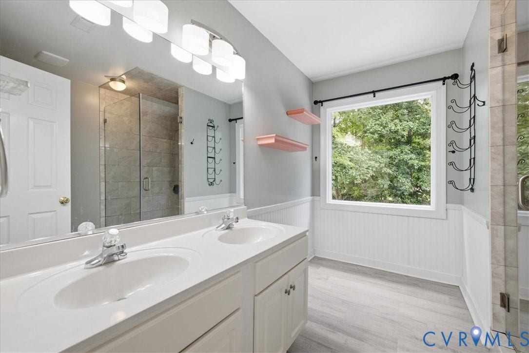 The updated primary bathroom features a dual vanity and...