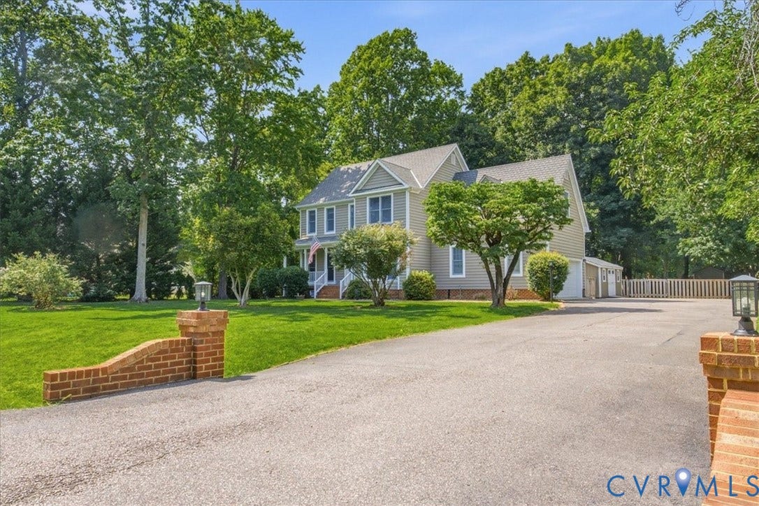 Traditional-style residence featuring light gray siding and white trim