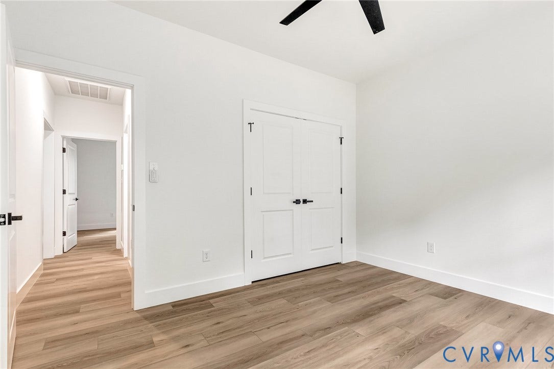 716 Pine Harbour Drive, Pine Harbour, Mineral, VA 23117 Room featuring wood-finish flooring, white walls, a ceiling fan with black blades, and a double-door closet with black hardware