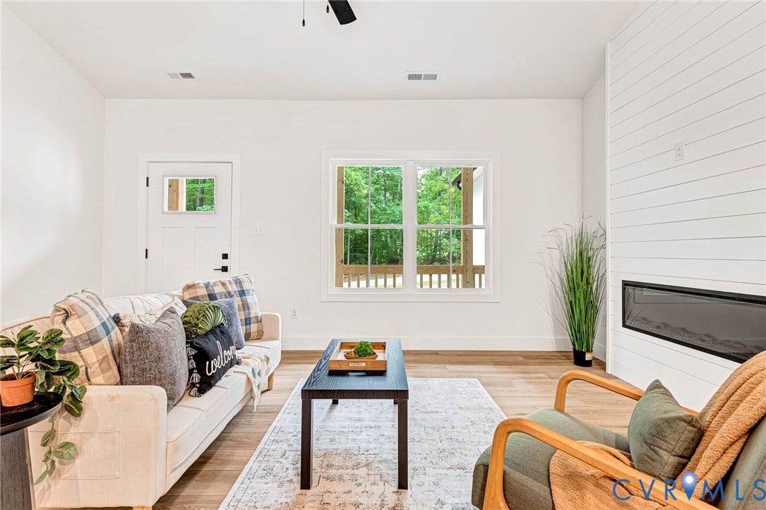 716 Pine Harbour Drive, Pine Harbour, Mineral, VA 23117 Living room featuring wood-finish flooring, white walls, and a modern linear fireplace with a shiplap accent wall
