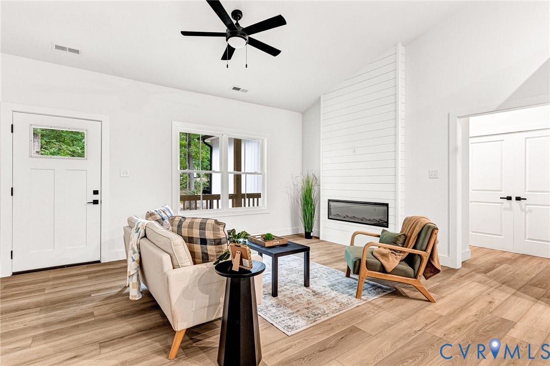 716 Pine Harbour Drive, Pine Harbour, Mineral, VA 23117 Living area featuring wood-finish flooring, a contemporary electric fireplace with shiplap surround, and a ceiling fan