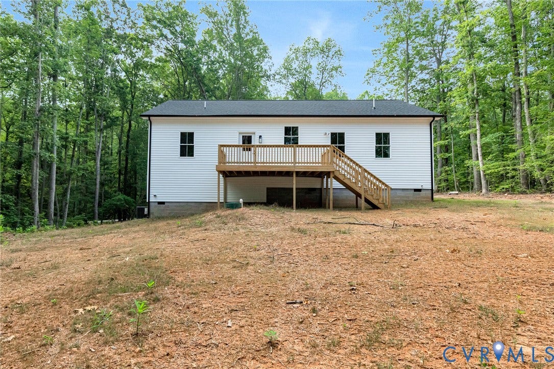 716 Pine Harbour Drive, Pine Harbour, Mineral, VA 23117 Rear exterior featuring white horizontal siding, a black shingle roof, and a wooden deck with stairs