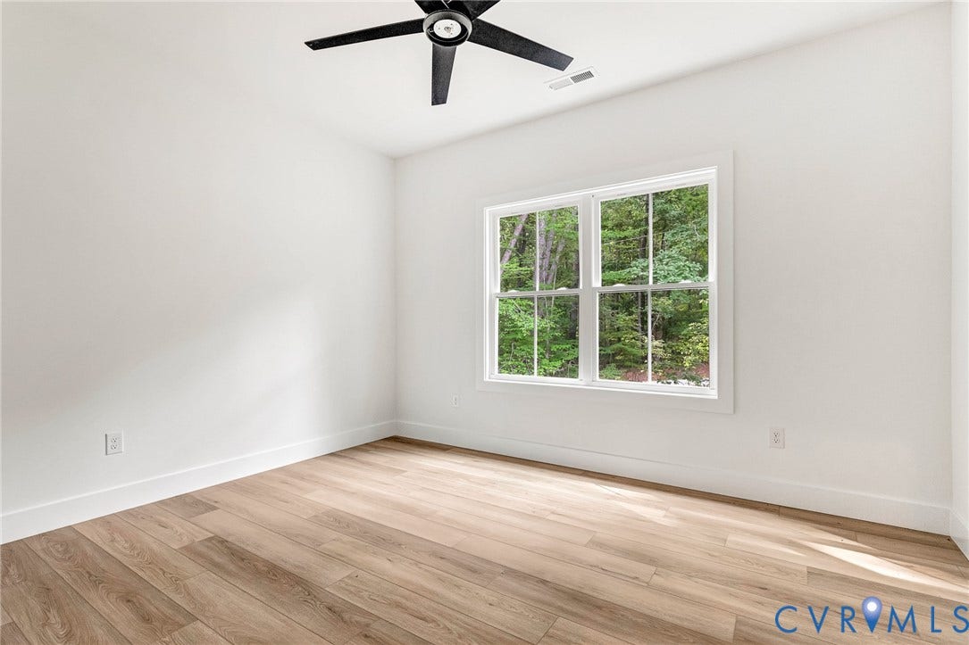 716 Pine Harbour Drive, Pine Harbour, Mineral, VA 23117 Spacious room featuring wood-finish flooring, white walls, and a large window