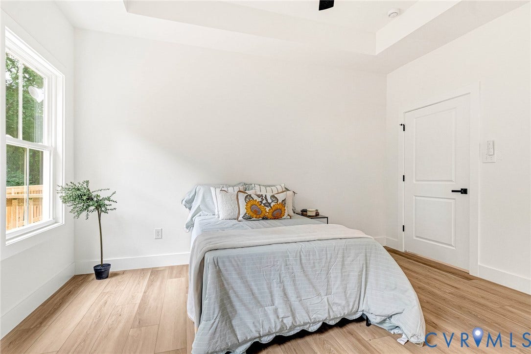 716 Pine Harbour Drive, Pine Harbour, Mineral, VA 23117 Bright room featuring light wood-finish flooring, white walls, and a tray ceiling
