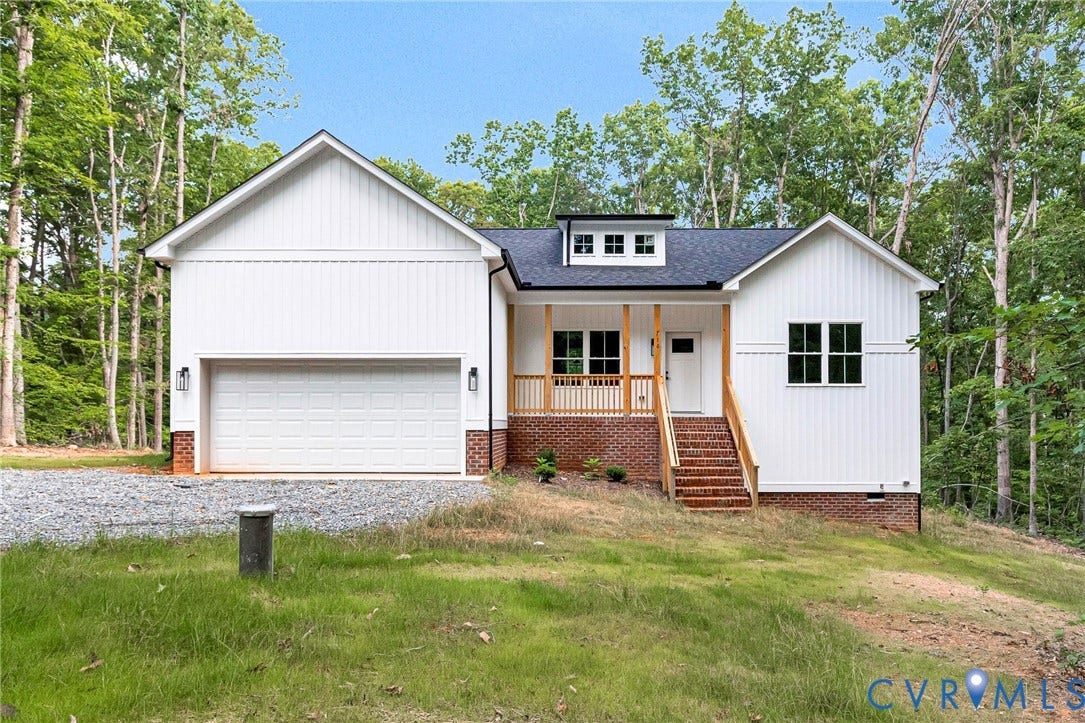 716 Pine Harbour Drive, Pine Harbour, Mineral, VA 23117 Modern farmhouse exterior featuring white board-and-batten siding, a dark shingle roof, and a welcoming covered porch with natural wood railings