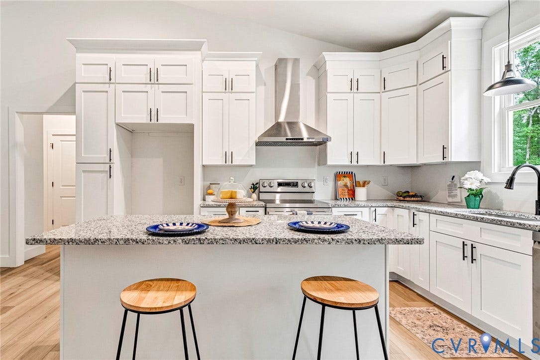 716 Pine Harbour Drive, Pine Harbour, Mineral, VA 23117 Modern kitchen featuring an island with a speckled countertop, white cabinetry, stainless steel appliances, and wood-finish flooring