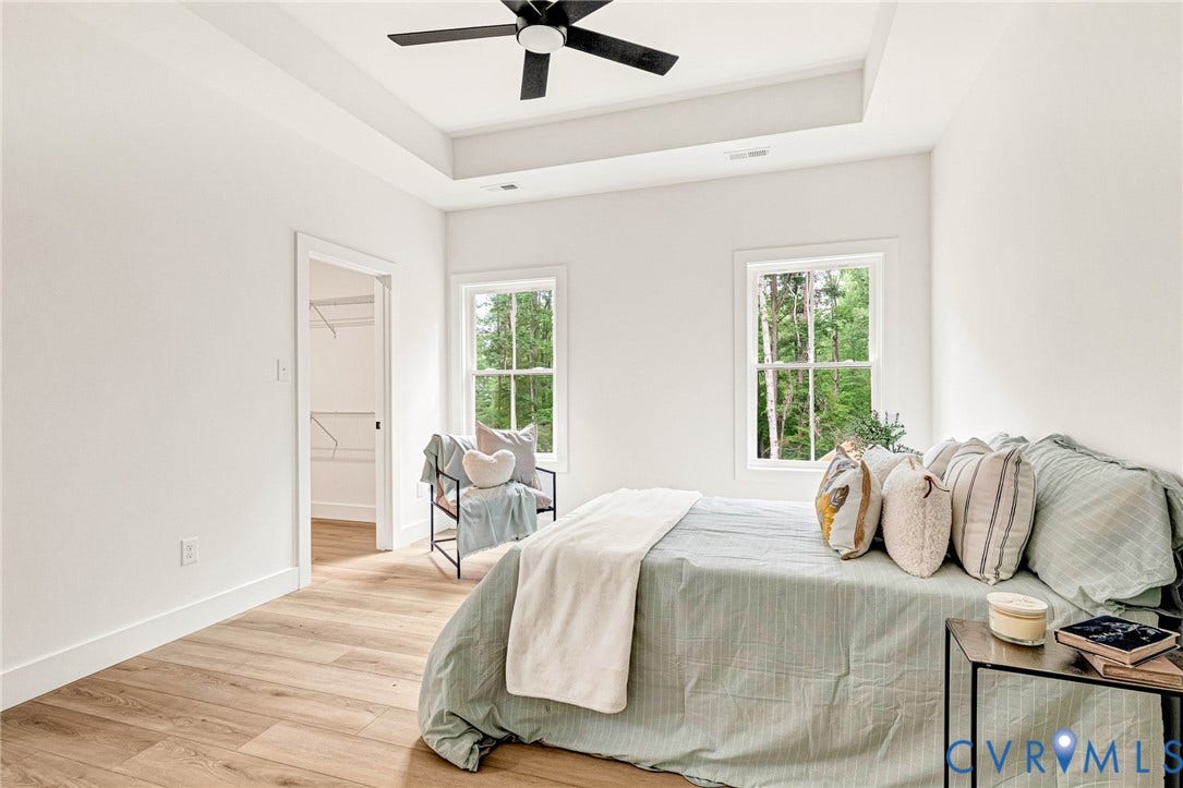 716 Pine Harbour Drive, Pine Harbour, Mineral, VA 23117 Bedroom featuring wood-finish flooring, a tray ceiling with a black ceiling fan, and two large windows
