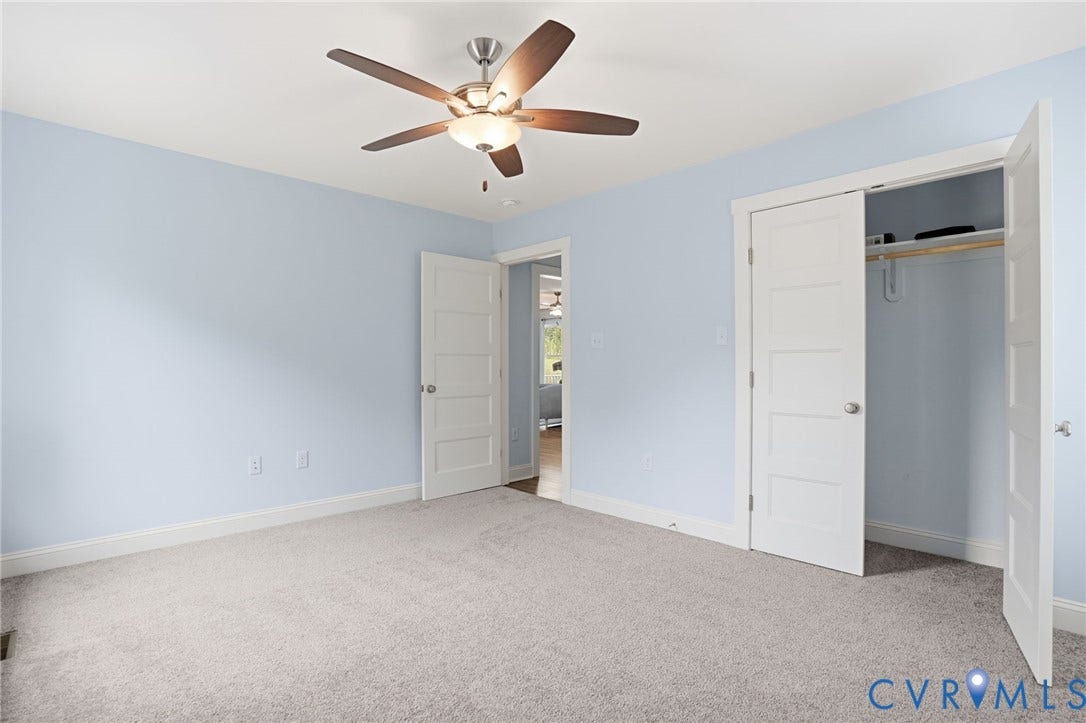 2677 Dogtown Road, Goochland, VA 23063 Carpeted room featuring a ceiling fan with integrated lighting, a five-panel interior door, and a closet with a bi-fold door and built-in shelving