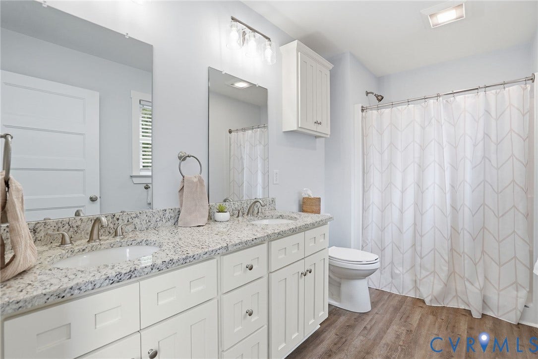 2677 Dogtown Road, Goochland, VA 23063 Dual sink vanity featuring a speckled countertop, white cabinetry, and brushed nickel fixtures