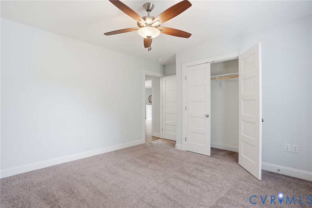2677 Dogtown Road, Goochland, VA 23063 Carpeted room featuring a ceiling fan with light fixture, white walls, white trim, and a bi-fold closet with shelving and hanging rod
