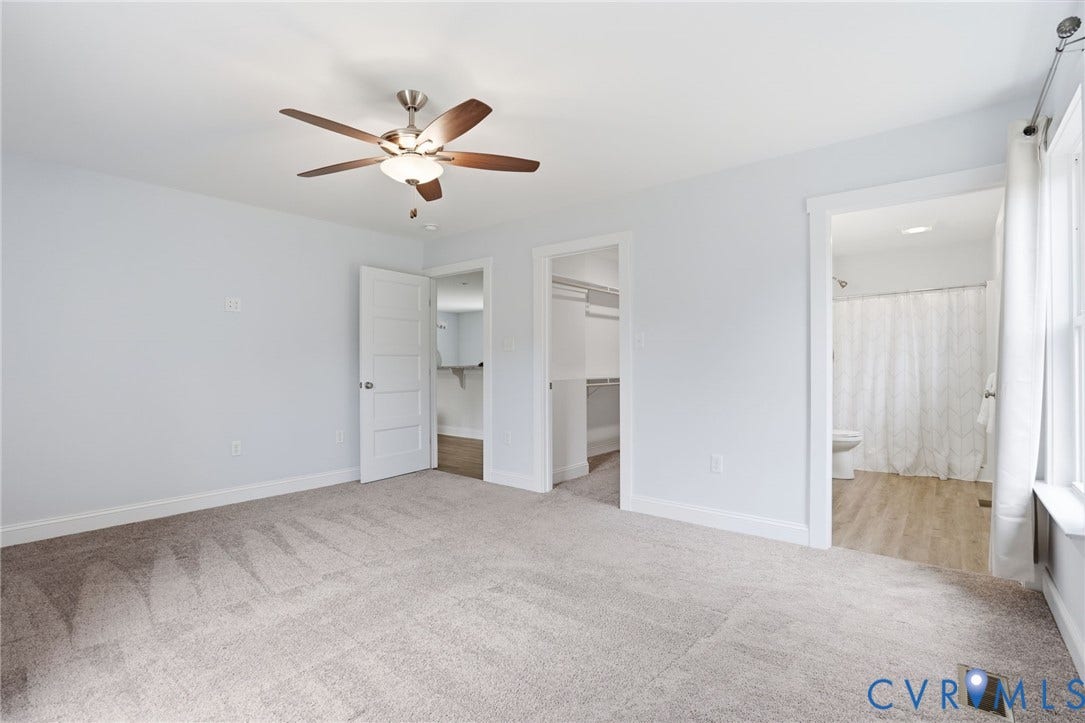 2677 Dogtown Road, Goochland, VA 23063 Spacious room featuring light-toned carpeting, a ceiling fan with integrated lighting, and two doorways revealing additional interior spaces