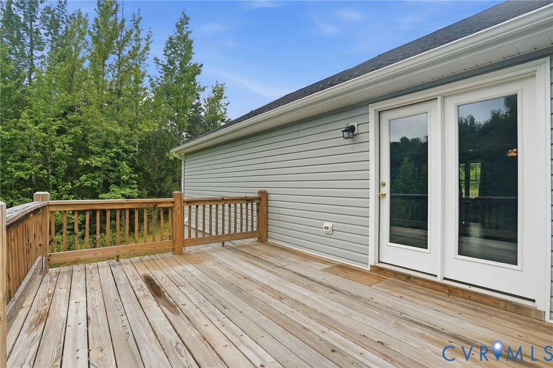 2677 Dogtown Road, Goochland, VA 23063 Spacious outdoor deck with a natural wood finish, wooden railing, and direct access to the interior via double glass-paned doors