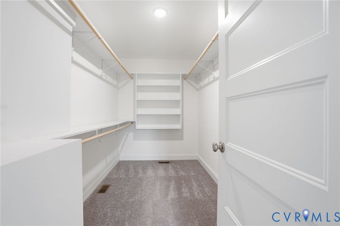 2677 Dogtown Road, Goochland, VA 23063 Walk-in closet featuring built-in shelving, dual hanging rods, a white two-panel door with a brushed nickel knob, recessed lighting, and gray carpet flooring