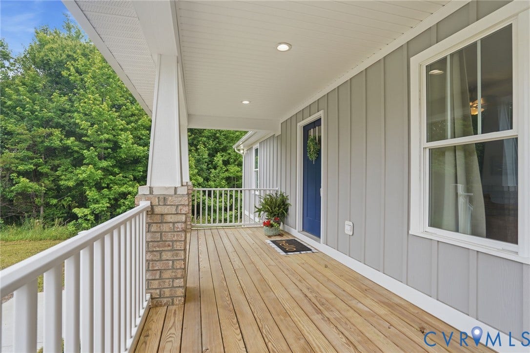 2677 Dogtown Road, Goochland, VA 23063 Inviting covered porch with natural wood flooring, white railing, and a brick-accented column