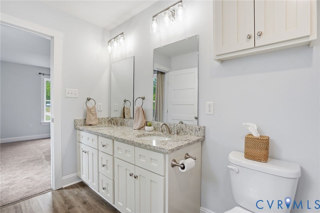 2677 Dogtown Road, Goochland, VA 23063 Dual sink vanity featuring white shaker cabinetry and granite countertops