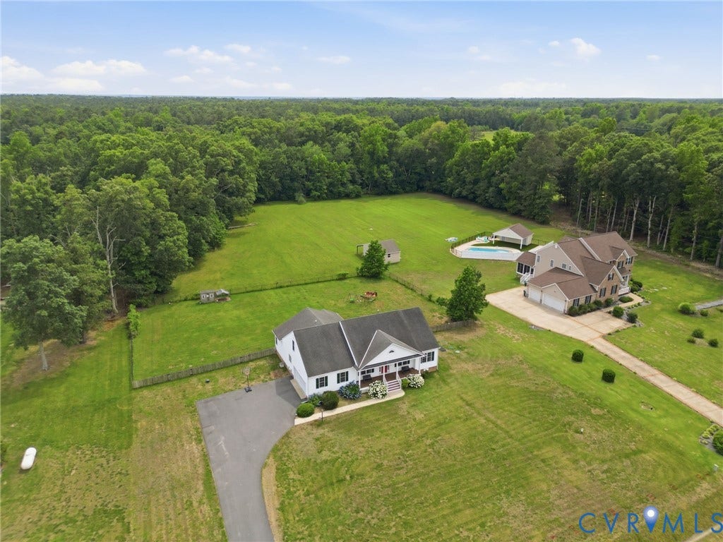 5305 Wellington Ridge Road, Richmond, VA 23231 Expansive property featuring two distinct residences, a detached garage, an in-ground swimming pool with a covered patio, and a large grassy field bordered by mature trees