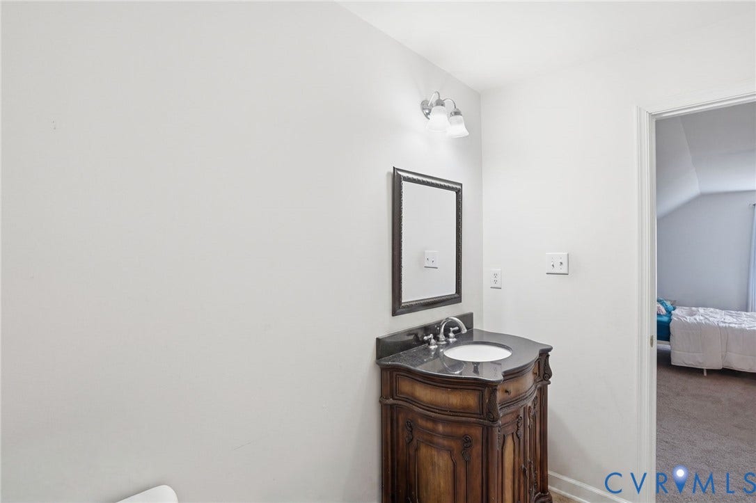 5305 Wellington Ridge Road, Richmond, VA 23231 Ornate wood vanity with an integral white sink and dark countertop