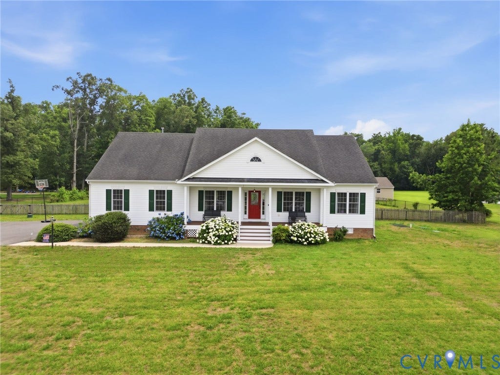 5305 Wellington Ridge Road, Richmond, VA 23231 Ranch-style residence featuring a white facade with dark green shutters, a welcoming red entry door, a covered front porch, a gabled dormer, and a spacious front lawn
