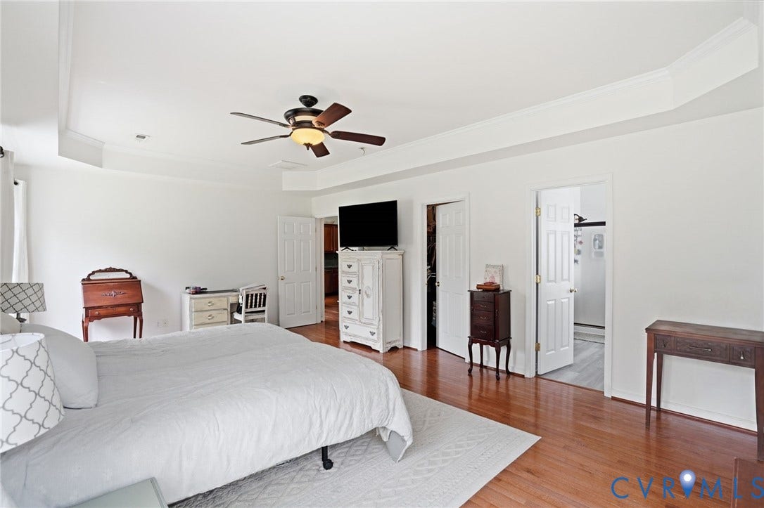 5305 Wellington Ridge Road, Richmond, VA 23231 Spacious room featuring wood-finish flooring, white walls, and a recessed tray ceiling with crown molding